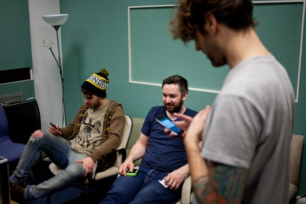 Checking phones upon arriving in the green room while The School clear out of the studio.